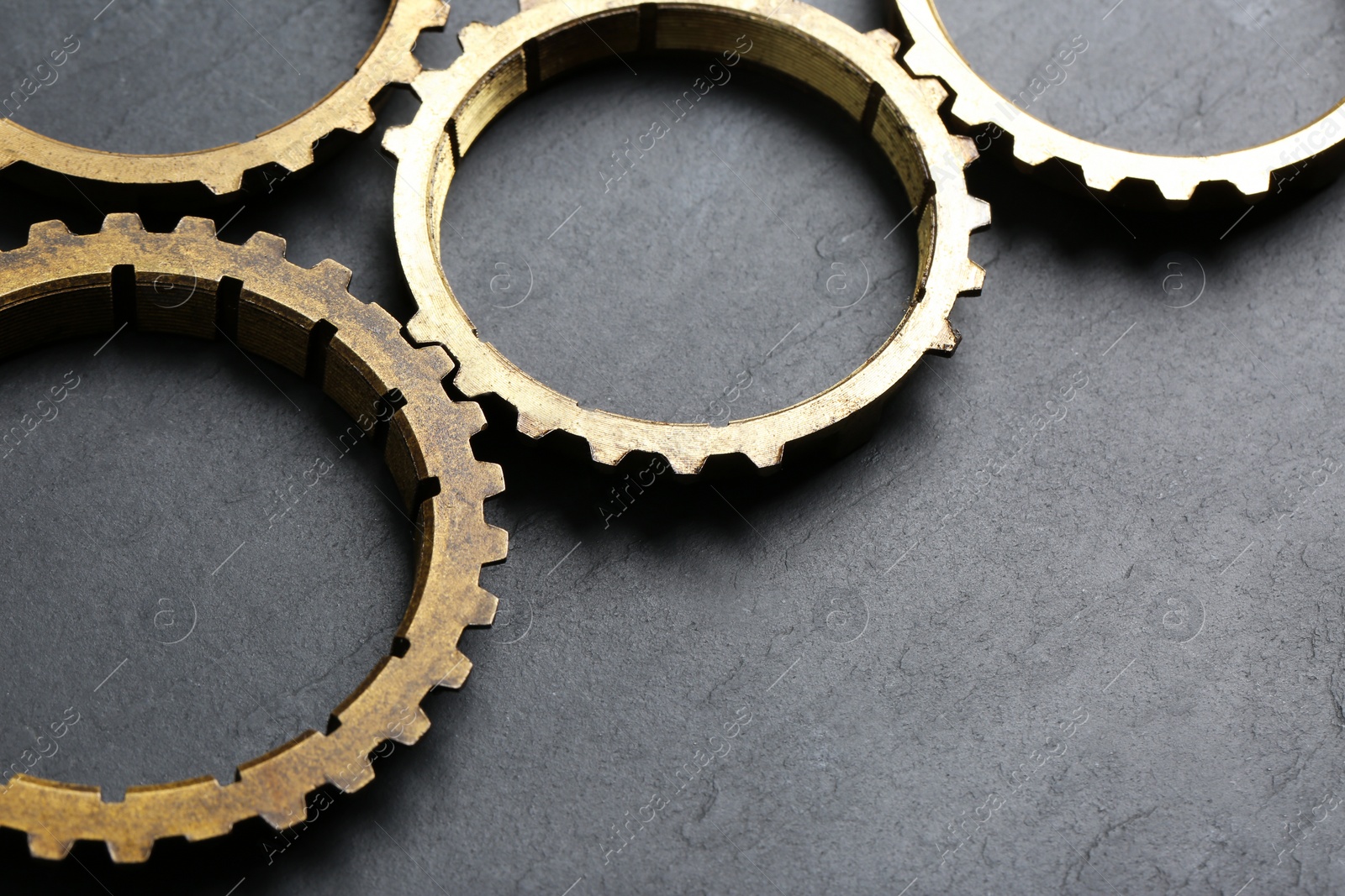 Photo of Stainless steel gears on grey background, closeup. Space for text