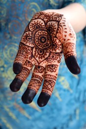 Photo of Woman with henna tattoo on palm, closeup. Traditional mehndi ornament