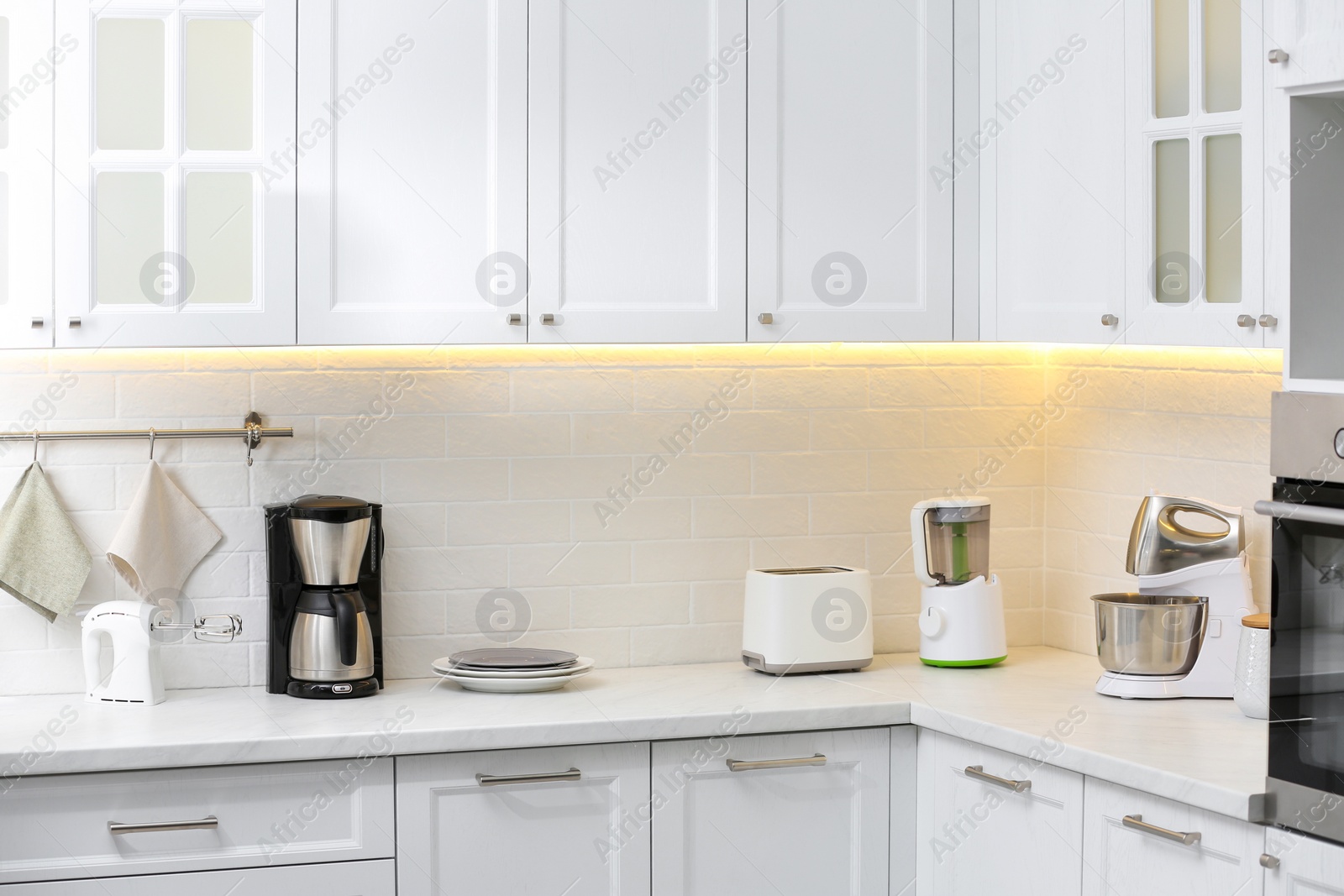 Photo of Modern toaster and other cooking appliances on countertop in kitchen