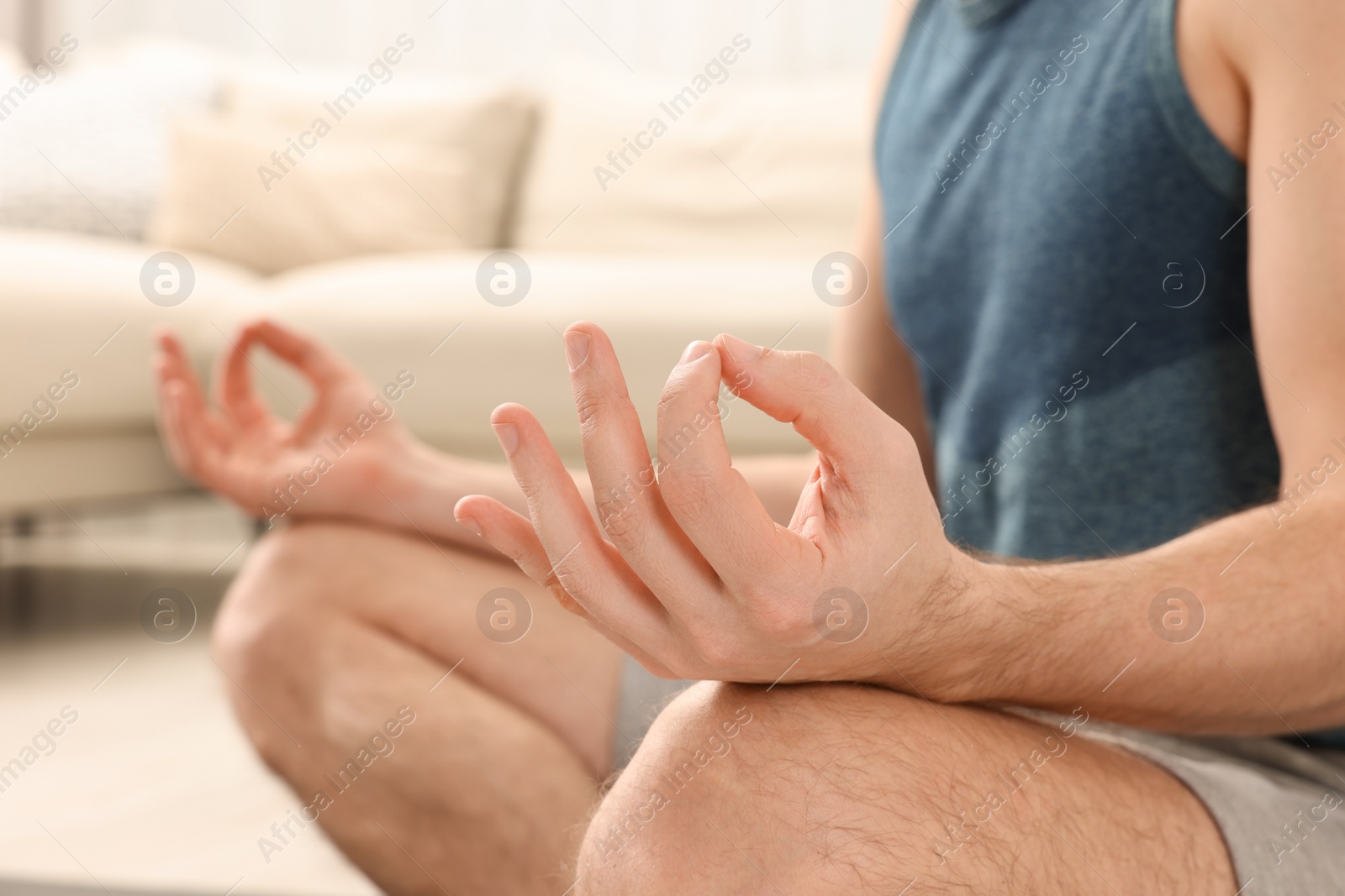 Photo of Man in sportswear meditating at home, closeup. Harmony and zen