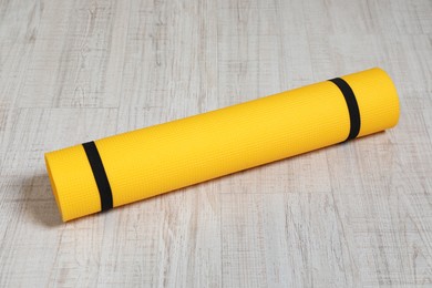 Bright rolled camping mat on white wooden background
