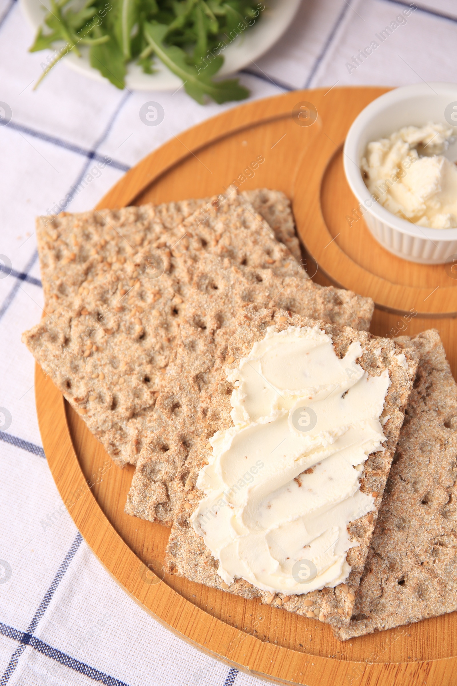 Photo of Fresh crunchy crispbreads with cream cheese on table, above view