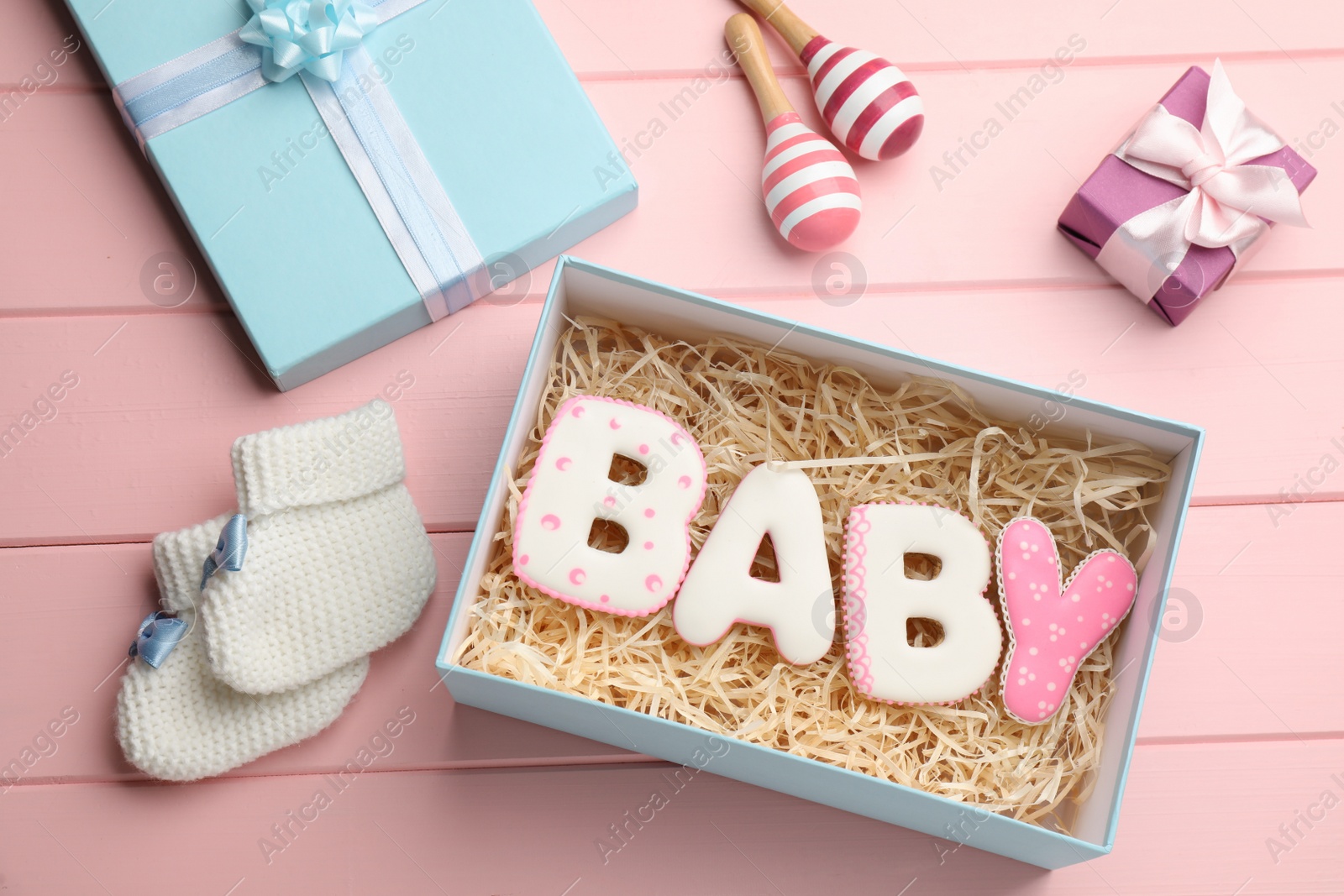 Photo of Baby shower party. Flat lay composition with gift boxes and cookies on pink wooden background