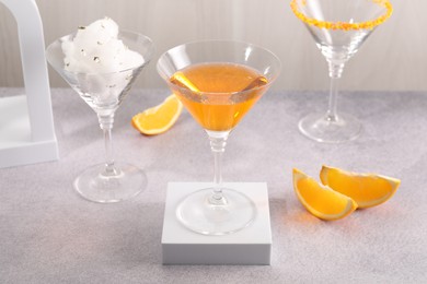 Photo of Cotton candy and cocktails in glasses on gray table