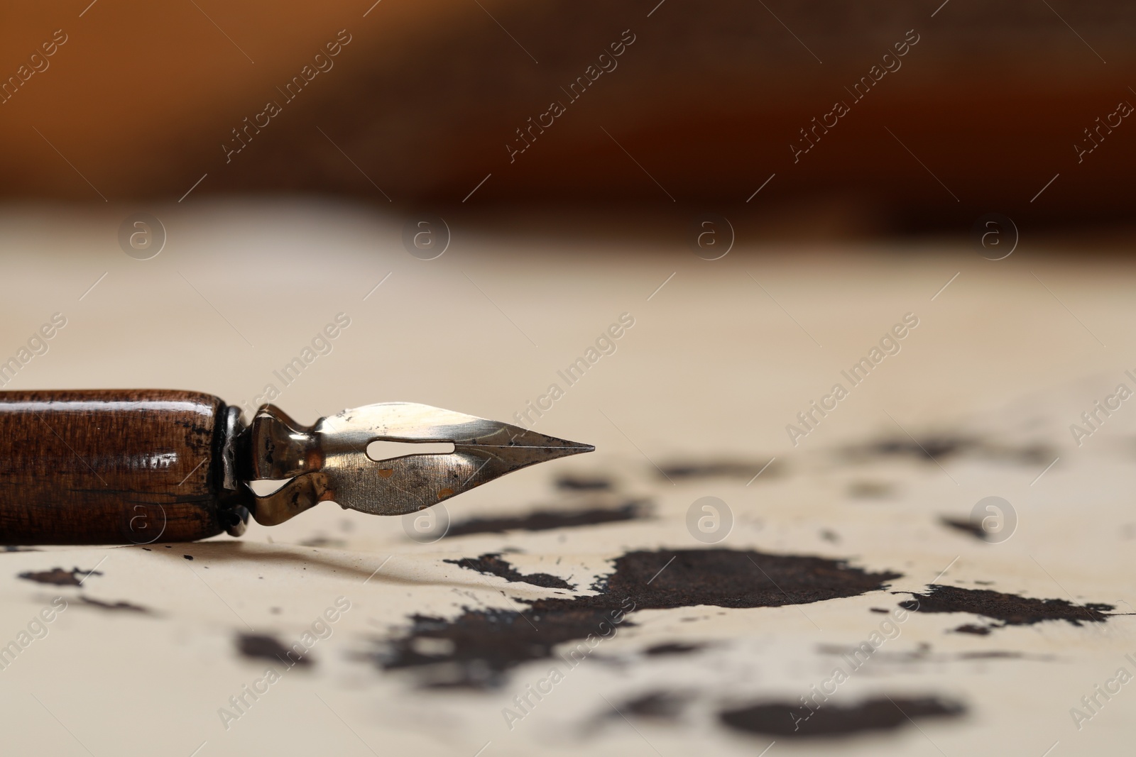 Photo of Fountain pen on vintage parchment with ink stains, closeup. Space for text