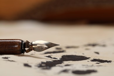 Fountain pen on vintage parchment with ink stains, closeup. Space for text