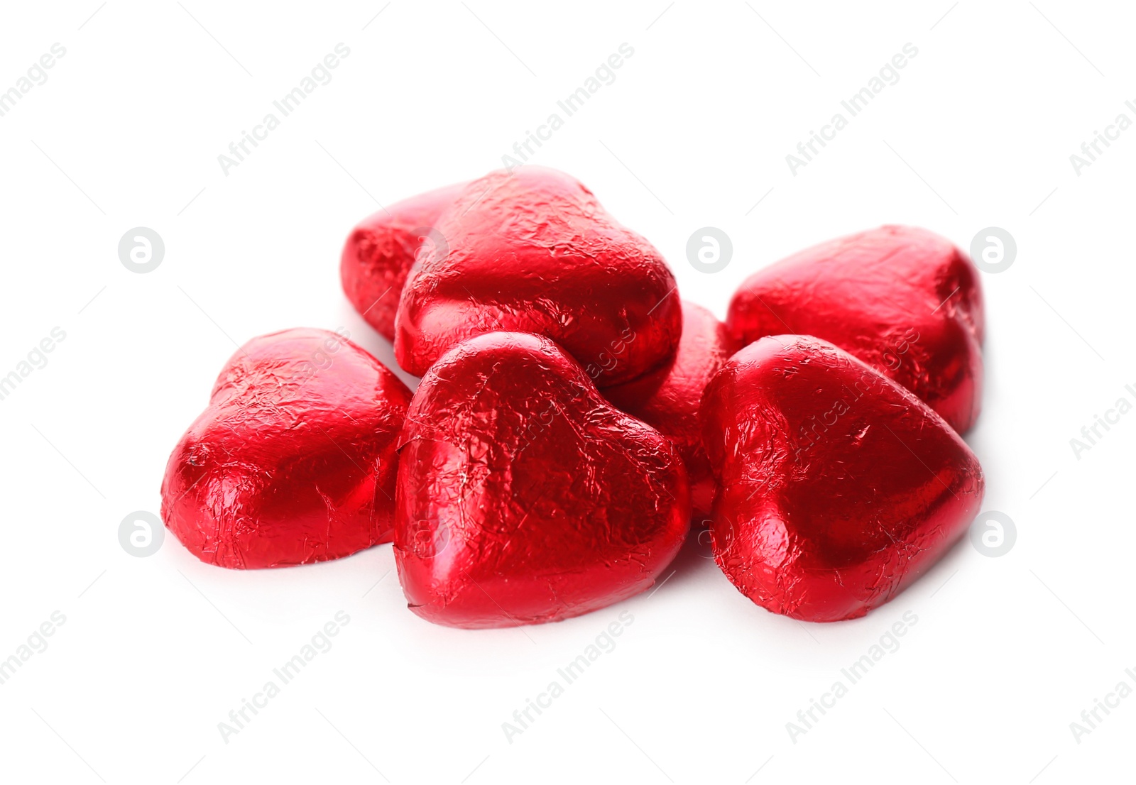 Photo of Heart shaped chocolate candies in red foil on white background