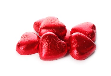 Photo of Heart shaped chocolate candies in red foil on white background