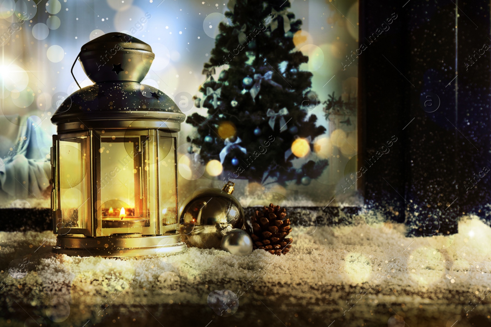 Image of Lantern with candle, baubles and pine cone near window outdoors. Christmas eve