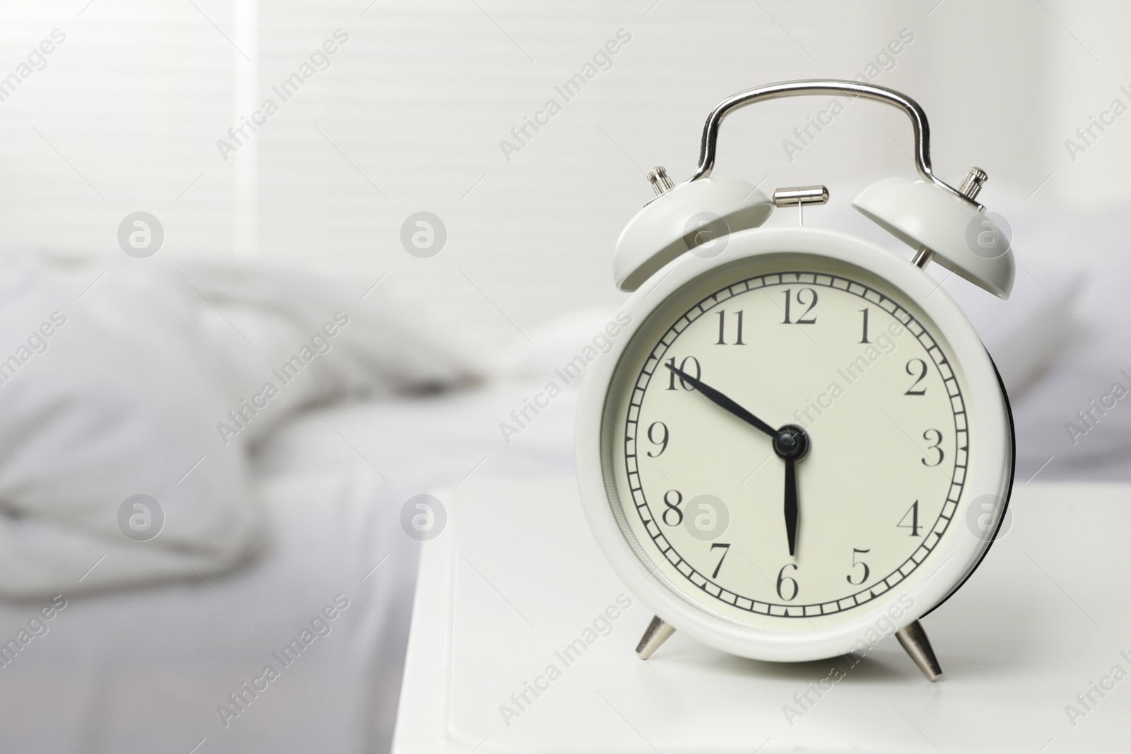 Photo of Alarm clock on white nightstand in bedroom, space for text