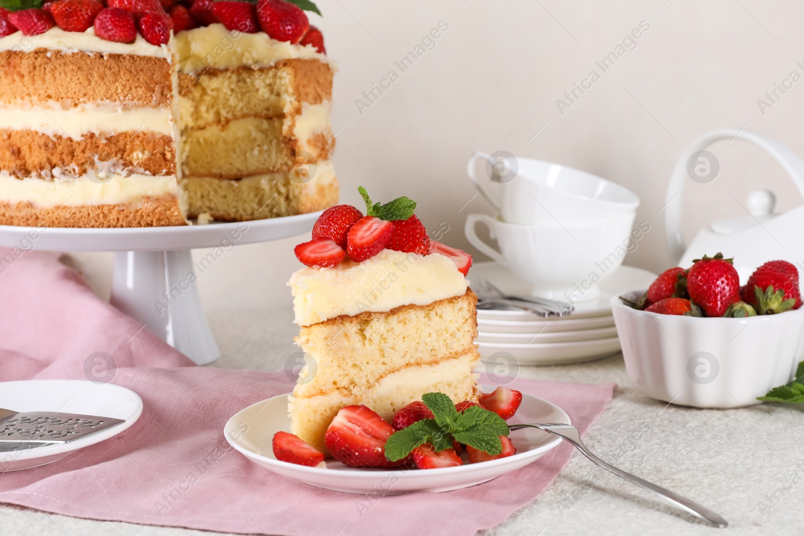 Photo of Piece of tasty cake with fresh strawberries and mint on white table