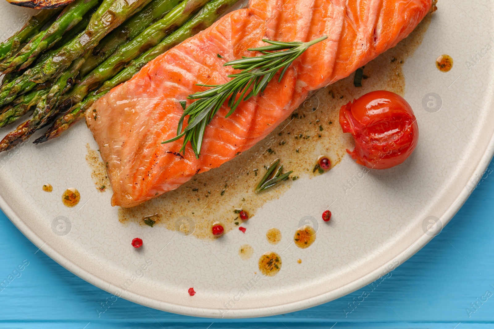 Photo of Tasty grilled salmon with tomato, asparagus and spices on table, top view