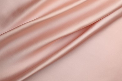 Photo of Crumpled pink silk fabric as background, top view