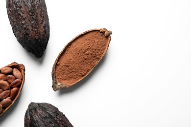 Cocoa pods with beans and powder on white background, top view