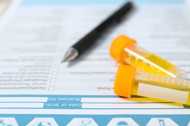 Photo of Containers with urine samples for analysis on medical report, closeup. Laboratory tests