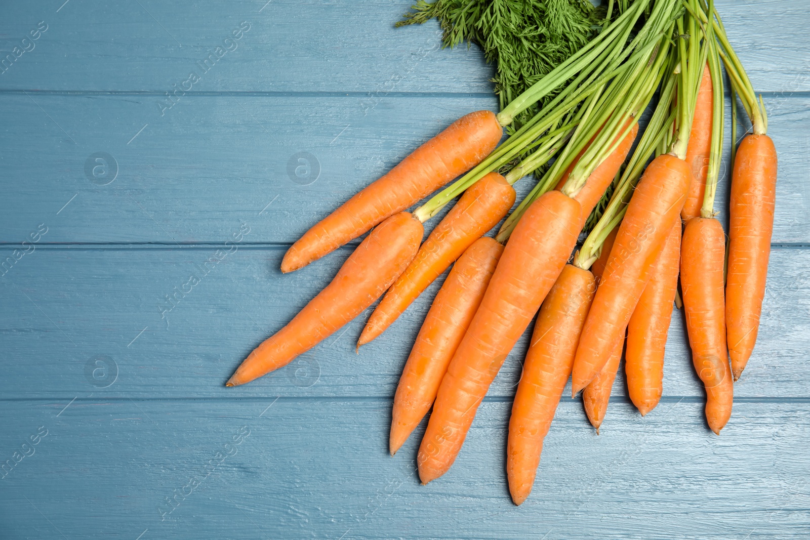 Photo of Ripe carrots on wooden background, top view