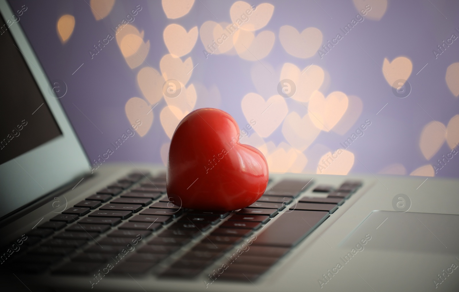 Photo of Red decorative heart on laptop, closeup. Online dating