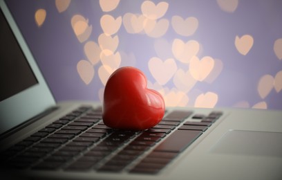 Photo of Red decorative heart on laptop, closeup. Online dating