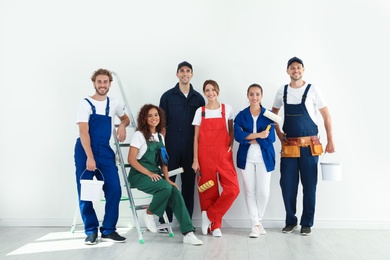 Photo of Team of professional painters with tools indoors