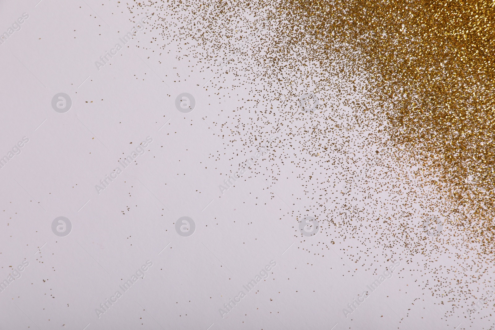 Photo of Shiny golden glitter on white background, top view