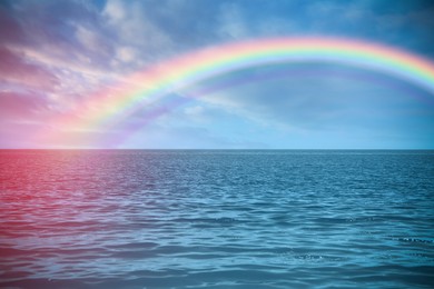 Image of Beautiful view of colorful rainbow in sky over sea