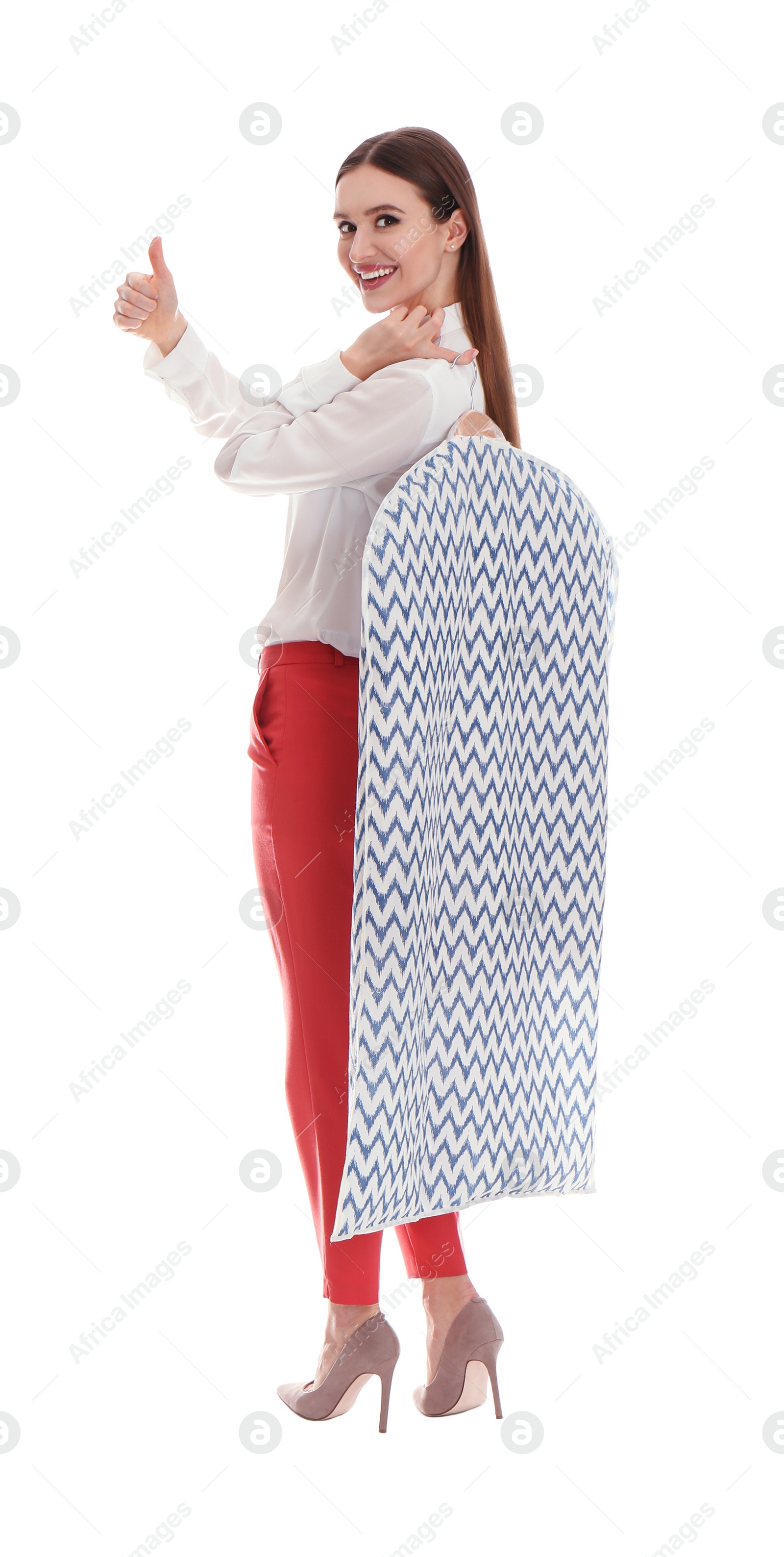 Photo of Young woman holding hanger with clothes in garment cover on white background. Dry-cleaning service