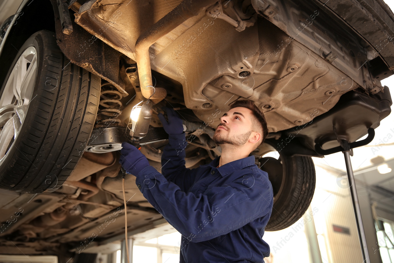 Photo of Technician checking modern car at automobile repair shop