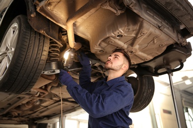 Photo of Technician checking modern car at automobile repair shop