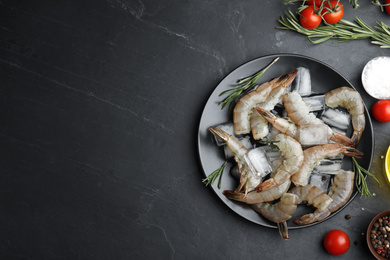 Flat lay composition with fresh raw shrimps on black table. Space for text