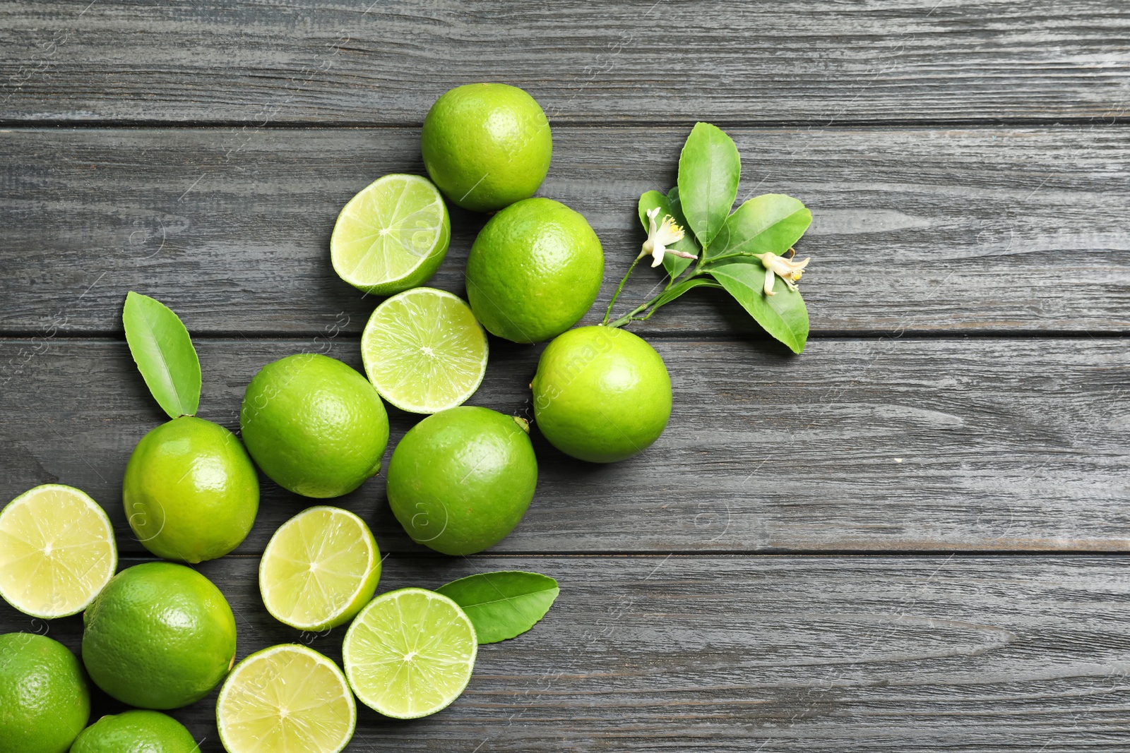 Photo of Composition with fresh ripe limes on wooden background, top view