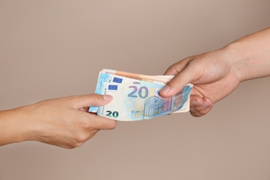 Photo of People with Euro banknotes on brown background, closeup