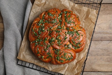 Traditional Ukrainian garlic bread with herbs (Pampushky) on wooden table, flat lay