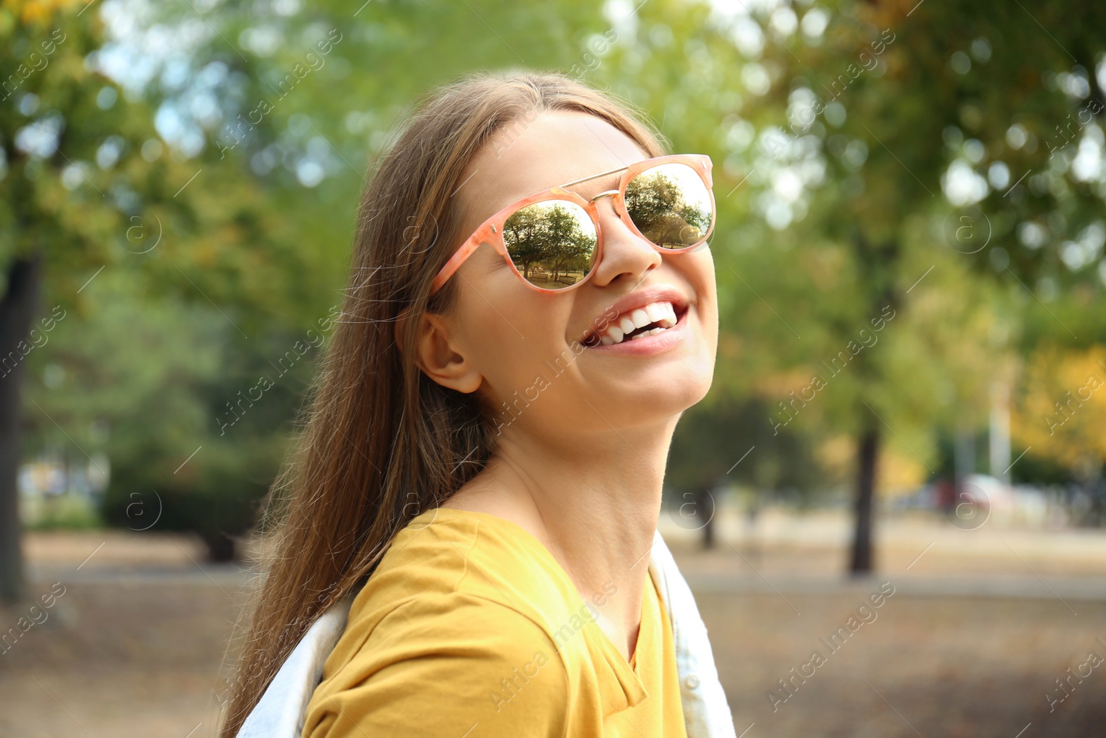 Photo of Young woman wearing stylish sunglasses in park