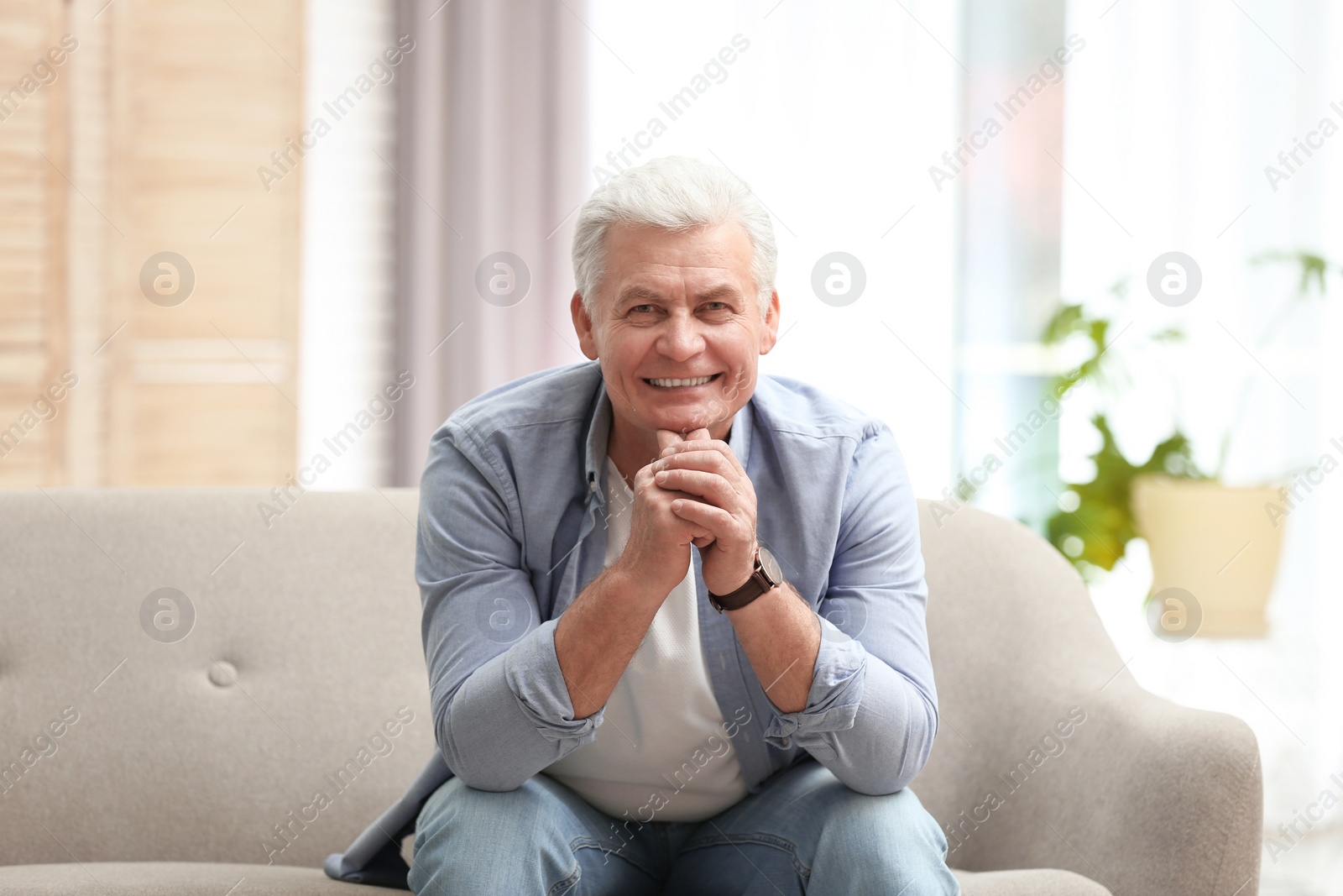 Photo of Portrait of handsome mature man on sofa indoors