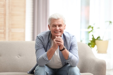 Photo of Portrait of handsome mature man on sofa indoors