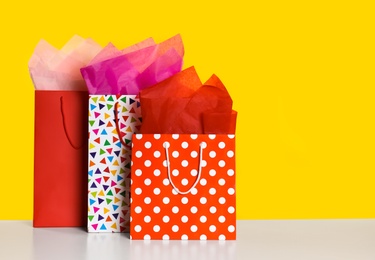 Shopping bags with paper on yellow background. Space for text