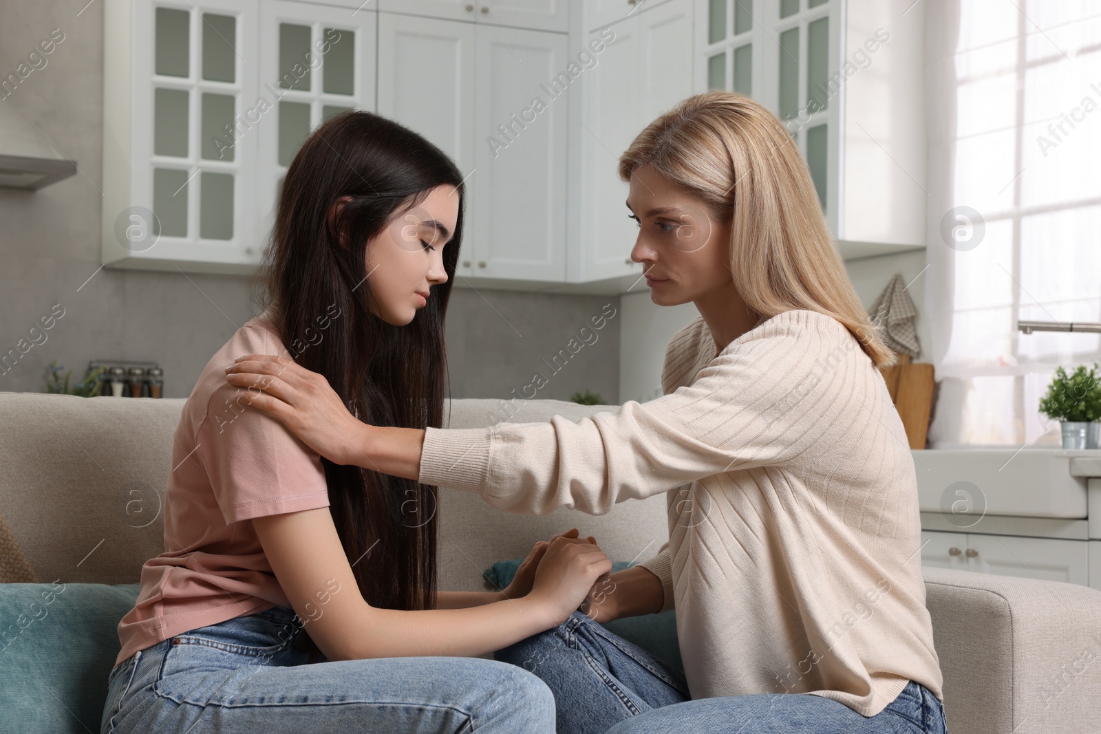 Photo of Mother consoling her upset daughter at home. Teenager problems