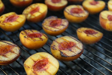 Photo of Modern grill with tasty cut peaches, closeup