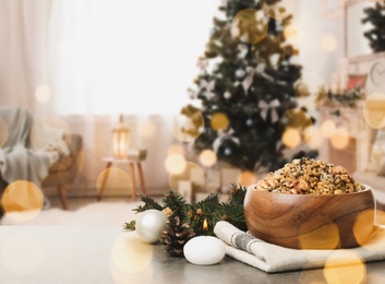 Traditional Christmas slavic dish kutia on table in decorated room. Space for text