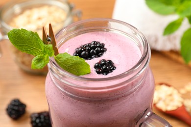 Photo of Delicious blackberry smoothie in mason jar, closeup