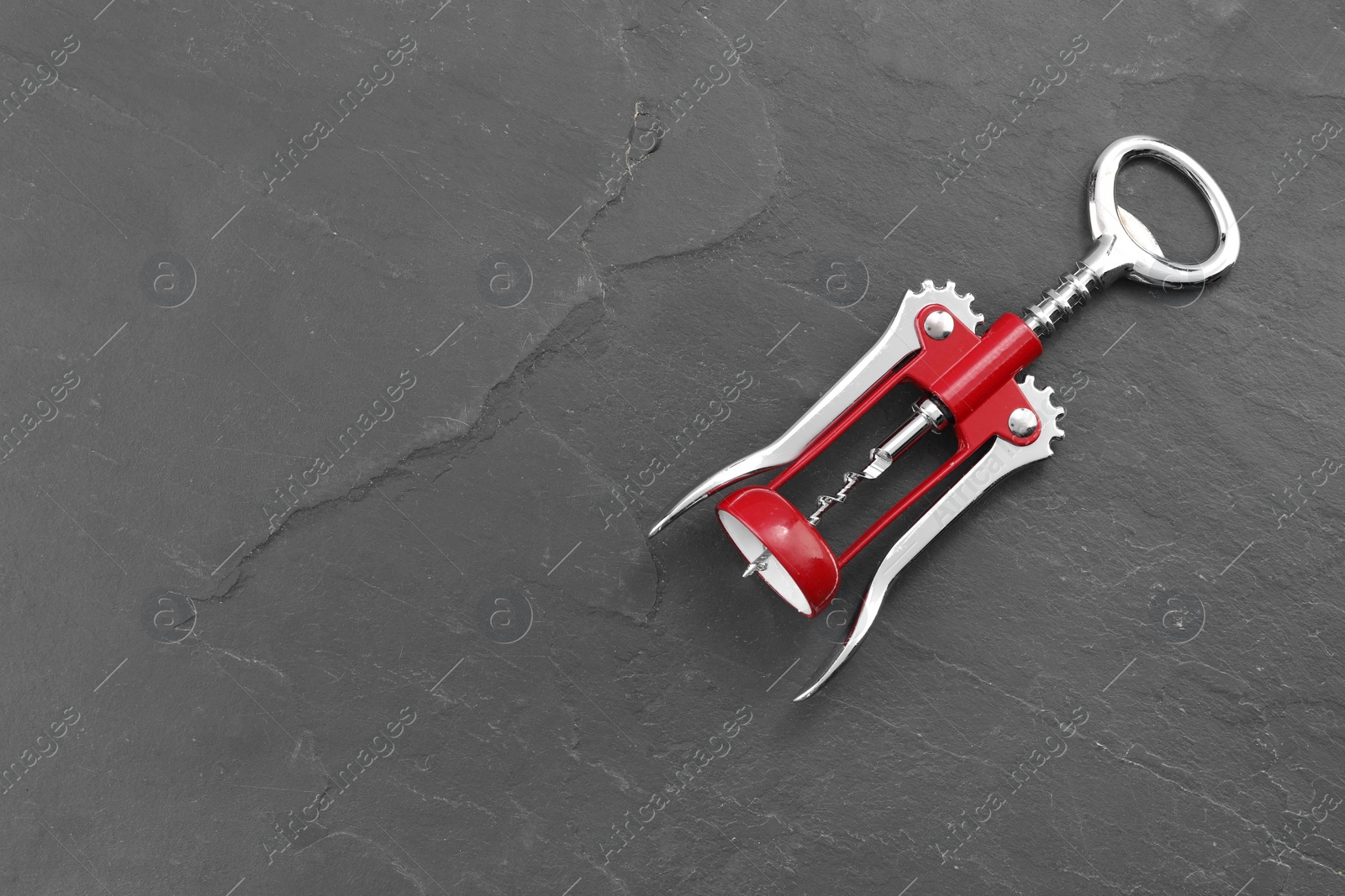 Photo of One wing corkscrew on grey textured table, top view. Space for text