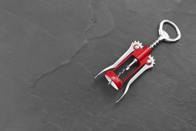 One wing corkscrew on grey textured table, top view. Space for text