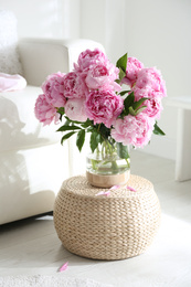 Bouquet of beautiful peonies on pouf indoors