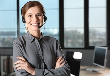 Photo of Female technical support operator with headset in office. Space for text