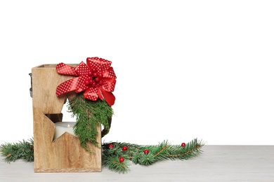 Wooden Christmas lantern with burning candle and fir branches on table. Space for text