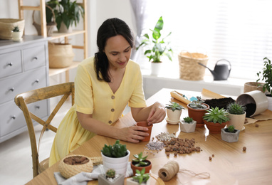 Mature woman potting plant at home. Engaging hobby