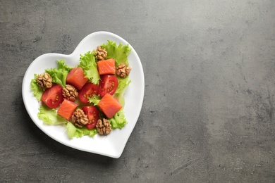 Photo of Plate of salad on grey background, top view with space for text. Heart-healthy diet