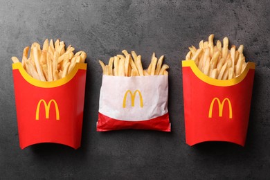 MYKOLAIV, UKRAINE - AUGUST 12, 2021: Small and big portions of McDonald's French fries on grey table, flat lay