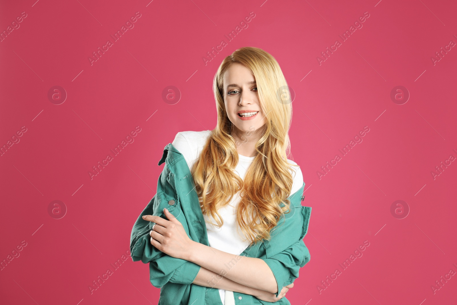 Photo of Portrait of beautiful young woman with dyed long hair on pink background