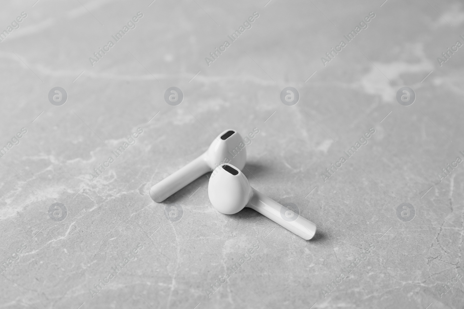 Photo of Wireless earphones on light grey marble table